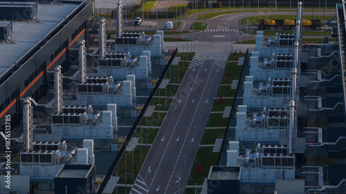 Aerial view of symmetrical rows of cooling units reflecting the soft light, contrasting with the dark building exteriors, Agriport, Middenmeer, Netherlands.