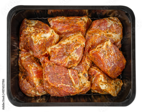 Fotografie Top view of raw pork neck pieces coated in spicy herb marinade packed in black p