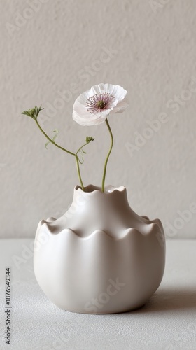 Elegant white flower in modern textured ceramic vase on neutral background
