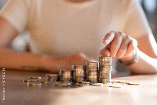 Photos The woman pointed to a pile of silver coins with her hand.
