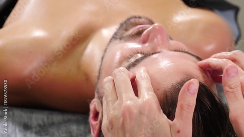 Massaging male head and skin of muscular athlete after workout. Sportsman receiving electric lift massage at spa salon. male client getting shoulders and neck massage. full body massage, Spa