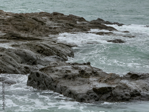 Massive coral rocks and sea waves in the coastal area of Wediombo Beach. A travel destination in Yogyakarta, Java, Indonesia, Asia.