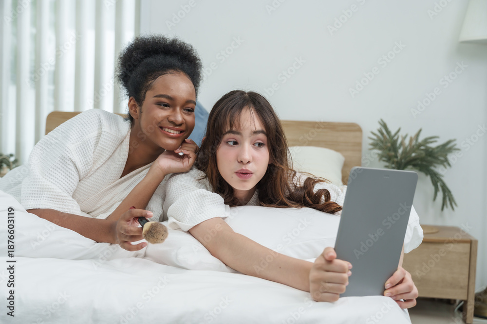 Fototapeta premium african american and asian teenage girls taking selfie with tablet on bed smiling during skincare session moment of natural beauty selfcare fun and youthful friendship in lifestyle and togetherness