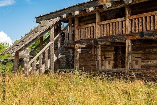 The impressive wooden walls of a reconstructed Old Slavic fortress, made of round, hewn logs. Old barracks and boyar chambers. A bright, sunny day.