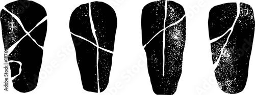 Ancient black stone tools with white fracture lines, prehistoric hand axes with worn textures