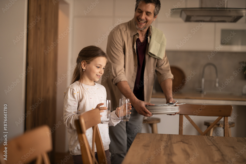 Fototapeta premium Father and daughter setting table for family lunch