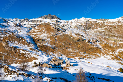 Winter view of the village of Blaunca, in Engadine, with snow-covered meadows.