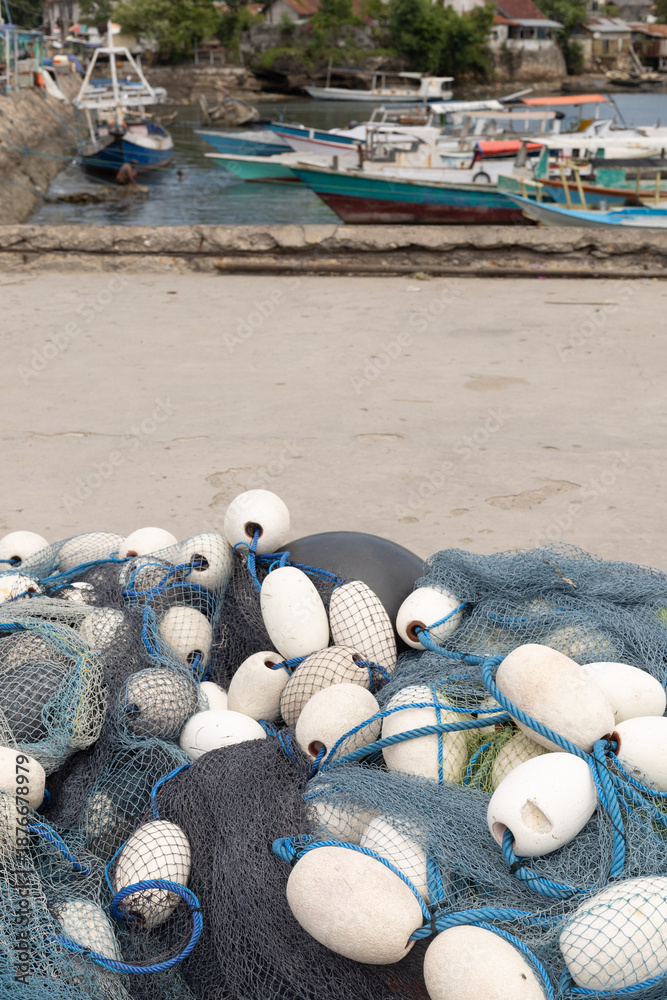 Obraz premium For over a month, strong winds have been alternatingly passing through Sumba, with boats taking shelter at the dock and local fishermen mending torn fishing nets