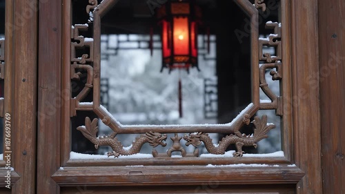 Traditional Chinese wooden window with dragon carvings and red lantern