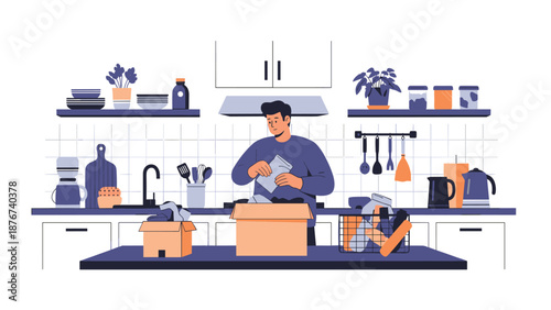 Young man stands in a modern kitchen while carefully packing items into cardboard boxes for a relocation or home move.