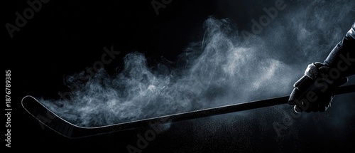Silhouette of hand holding hockey stick on dark dramatic background with light effects and steam. Powerful sports banner concept for hockey tournaments and championship promotion.