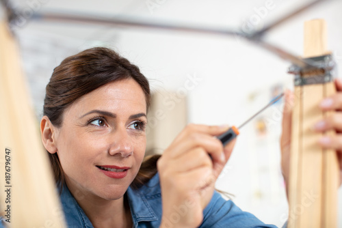 Quadro em tela woman assembling wooden furniture using hex key