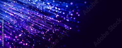 Abstract background of neon glowing light trails and bokeh spheres in pink, blue, and purple colors. High speed motion lines on dark background with shallow depth of field.