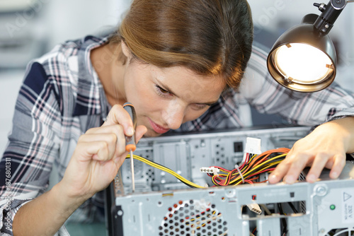 Wallpaper Mural young woman fixing a desktop computer seated at a table Torontodigital.ca
