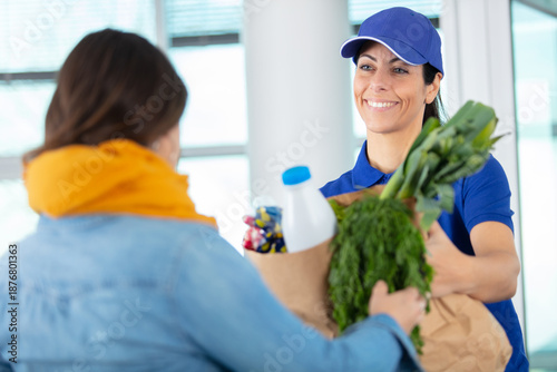 Фотография portrait of young woman delivering grocery basket
