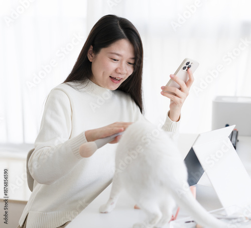The woman is petting the white cat.