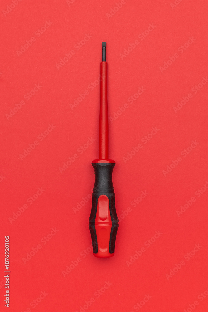 Obraz premium Red Screwdriver on Red Background: Minimalist Tool Design for Creative Projects