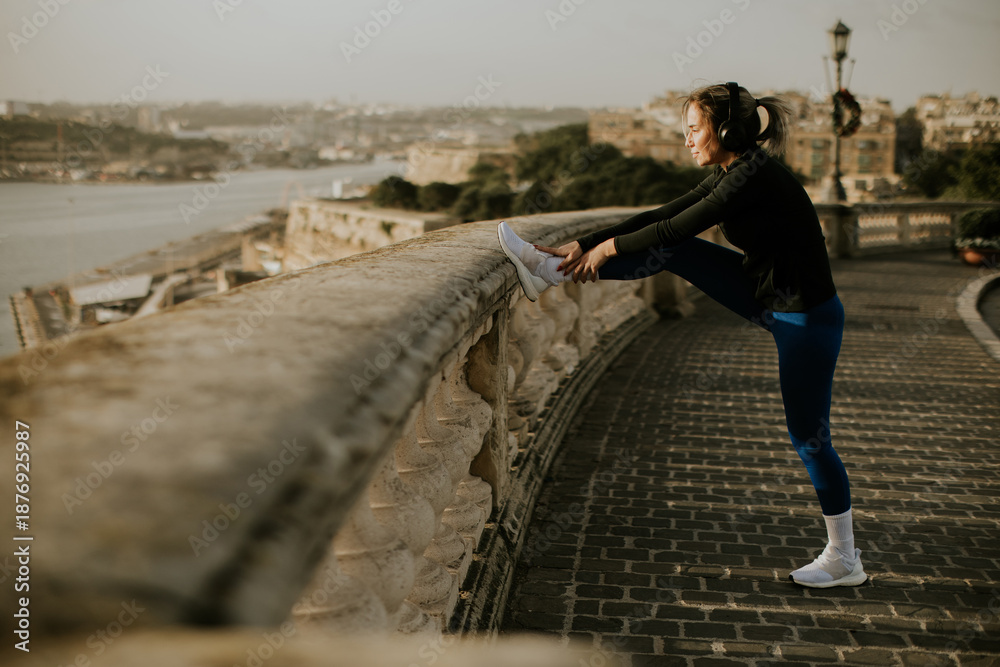 Obraz premium Woman stretching by the coast in Malta during morning exercise routine