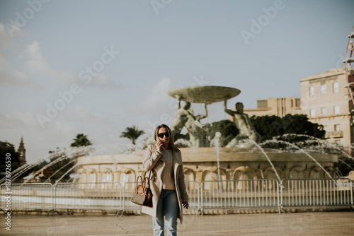 Woman walking by a fountain...