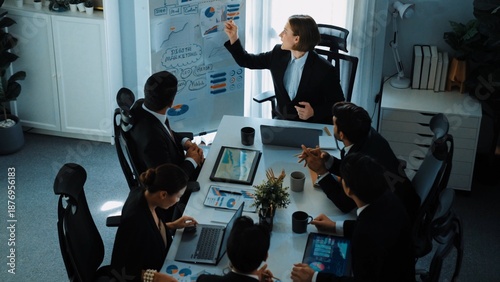Top view of smart manager project pointing at whiteboard with mind map and financial graph and explain marketing idea while diverse investors listening and analyze stock investment chart. Directorate.