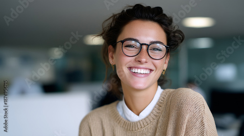 a cheerful professional businesswoman laughing and looking directly at the camera in a modern office environment. 