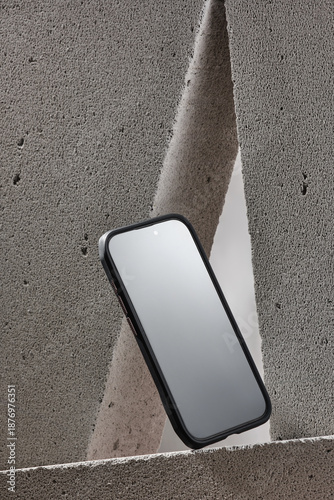 Stylish advertising composition of a smartphone in a protective case on a concrete background in a minimalist style.