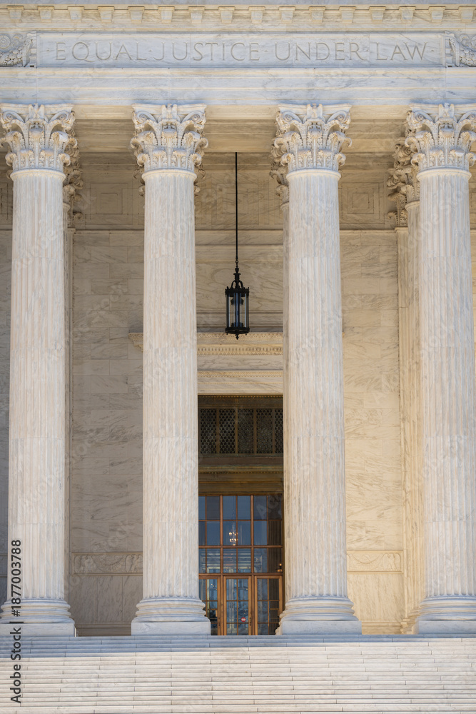 Fototapeta premium Marble pillars highlight timeless architecture. Historic government building with massive columns. Classical facade with elegant stone pillars. Court house exterior with refined architecture.