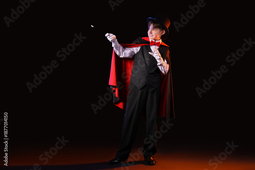 Billede på lærred Little magician with wand on dark background
