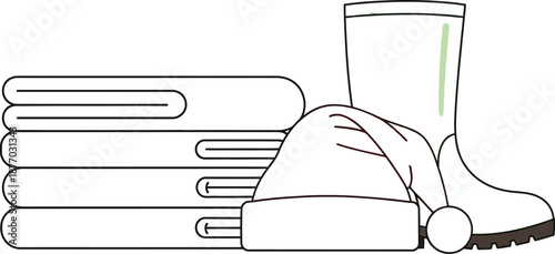 A hand holding a stack of books next to a rain boot and hat