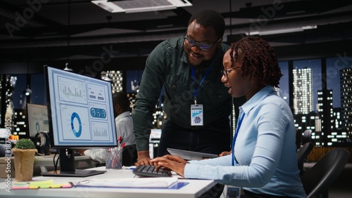 Black team of business colleagues analyzing data insights on desktop pc in office, consulting the analysis forecast before developing a new strategy for the enterprise activity.