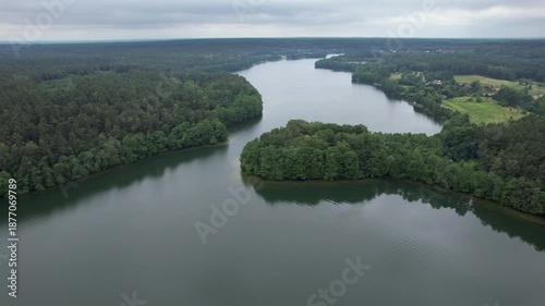 Forested Area With River Running Through it. Water is Calm and Clear. Trees Are Lush Sky is Cloudy. Dramatic Aerial View of Big Lake and Green Forest. Epic Amazing Nature Landscape Nature Reserve.