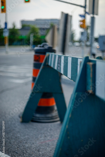 Road barrier and traffic cone at city intersection. Urban road construction, traffic restriction, safety concept, temporary closure, infrastructure and transportation control.