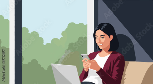 Cheerful young woman working on her laptop and using her smartphone from the comfort of her home, enjoying a connected modern lifestyle by a large window