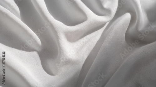 Soft white fabric texture with flowing folds and curves.