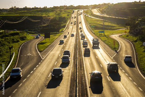 Wallpaper Mural Marilia, SP, Brazil, November 19, 2025. Highway SP-294 in Marilia, at sunset. Intense traffic of cars and trucks flows through the green landscape, illuminated by the golden hour light. Torontodigital.ca