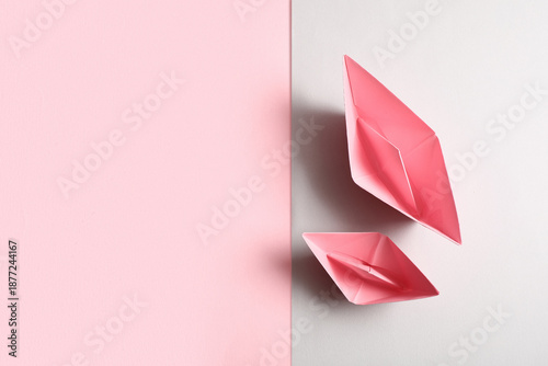 Pink origami boats on color...