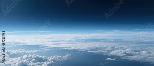 Stunning aerial view of Earth's atmosphere showing the clear transition from white clouds to a deep blue upper sky layer.
