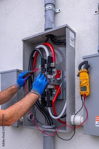 Fotografie Electrician measuring phase to neutral voltage at residential electric meter