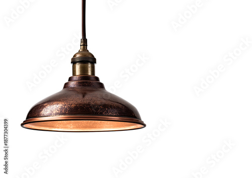 Copper pendant lamp with dim light against a stark black background