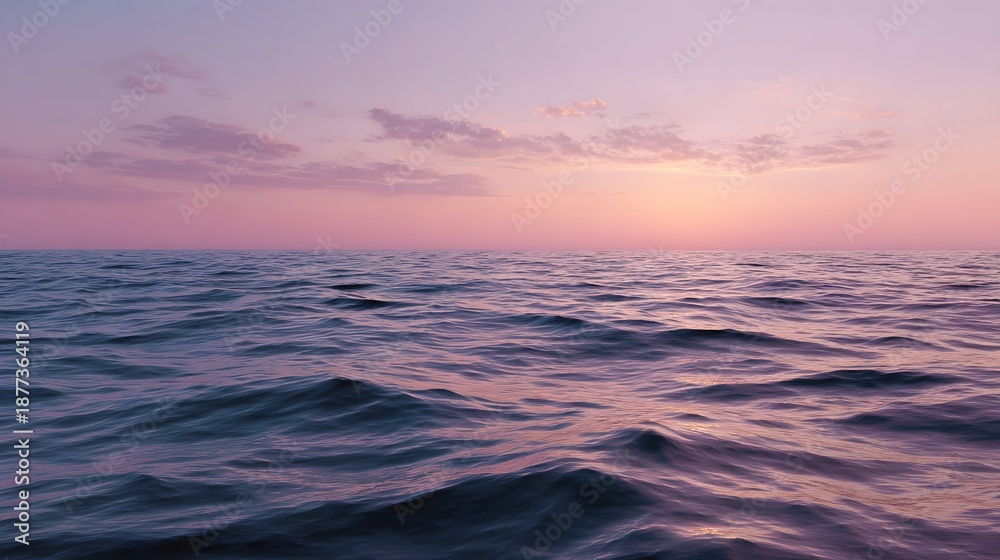Fototapeta premium Serene ocean surface reflecting pastel pink and purple sky at dawn or dusk