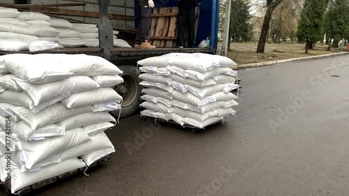 Forklift unloading pallet of sacks from truck.