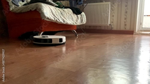A robot vacuum cleaner cleans the floor in the apartment.