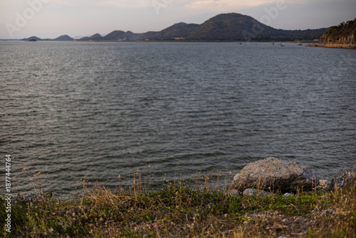 Grassy Slope By River At Dusk