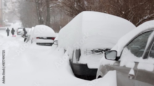 People are shoveling snow off a car that was covered in snow during the snowfall.
