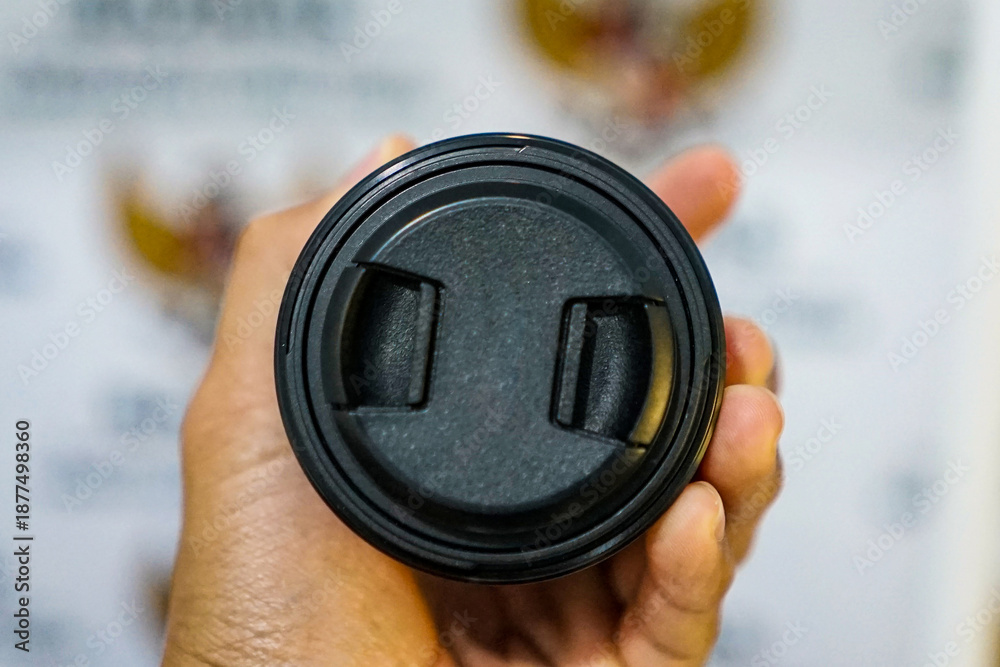 Fototapeta premium Camera lens held with blurred background