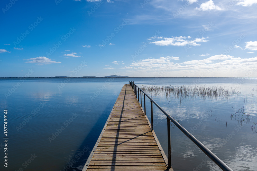 Fototapeta premium Wooden pier extending over Lake Colac, Victoria, Australia on a sunny day
