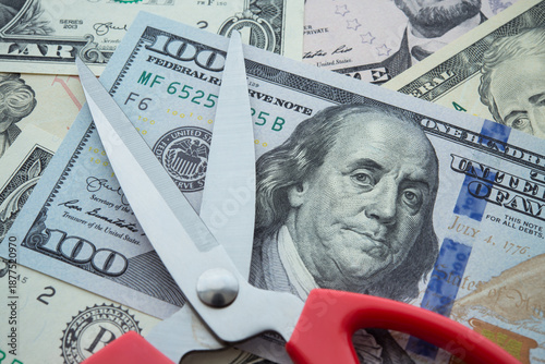 Scissors on US dollar banknotes background. Central banking system of the United States FED (Federal Reserve System) cut interest rate, world finance and economy concept.