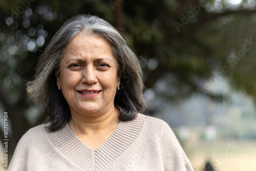 Fotografie Close shot of a happy indian elder woman fun at park