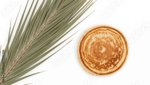 Palm leaf and pancake on white background connecting shrove tuesday and palm sunday traditions symbolizing borders, faith, and celebration