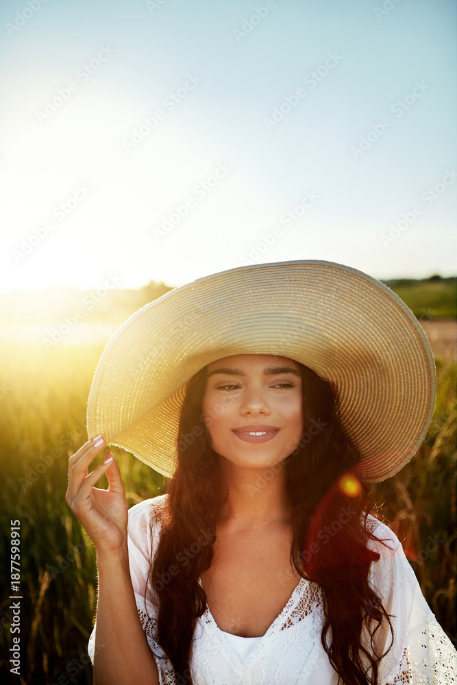 Fototapeta premium Thinking, woman and happy with hat outdoor for travel, fresh air and reflection on holiday. Space, female person and vacation with vision in field, daydreaming and sightseeing scenery in countryside